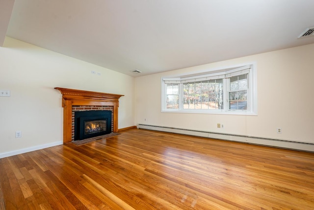 121 S Yarmouth Rd, Dennis, MA 02638 - unfurnished living room featuring baseboard heating, wood finished floors, a fireplace, and baseboards