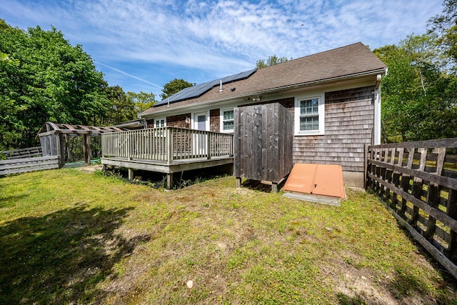 121 S Yarmouth Rd, Dennis, MA 02638 - rear view of house with a wooden deck and roof mounted solar panels