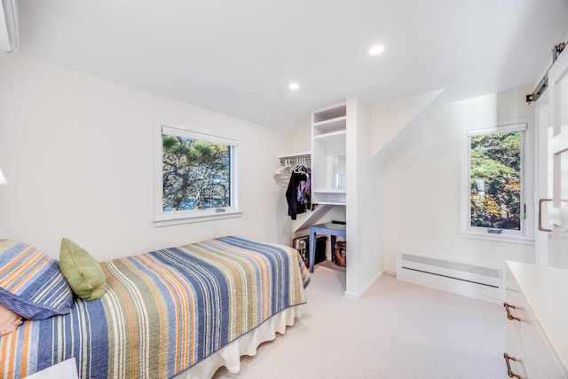 bedroom with a baseboard radiator, a closet, and light carpet