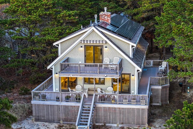 rear view of property featuring a balcony and a deck