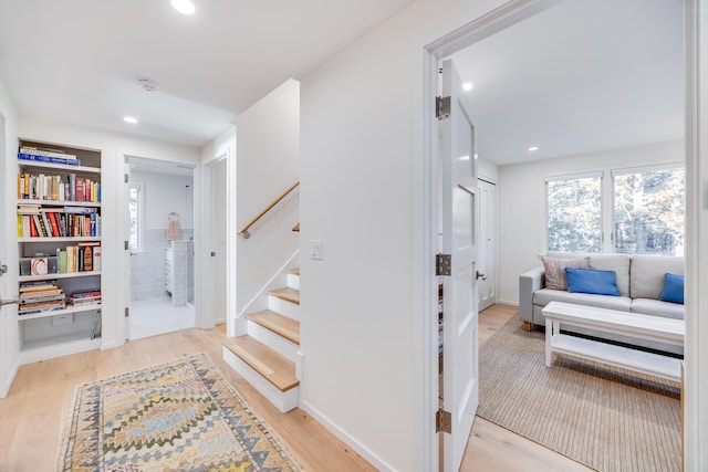 stairway featuring hardwood / wood-style flooring and built in shelves