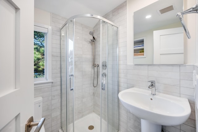 bathroom featuring sink, a wealth of natural light, and tile walls