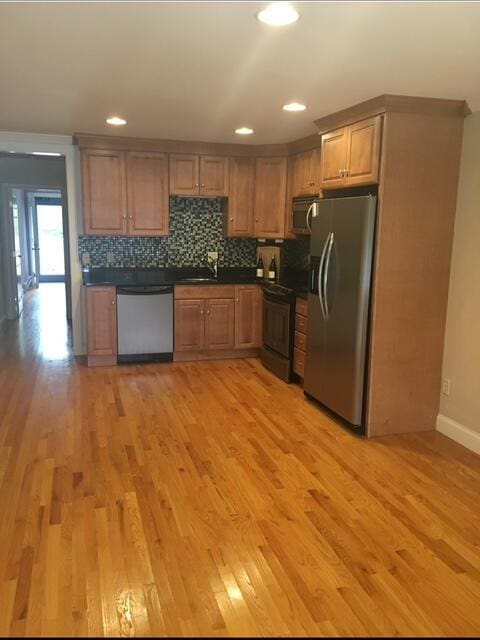 16 W Falmouth Hwy Unit 16, West Falmouth, MA 02540 - kitchen with appliances with stainless steel finishes, dark countertops, light wood-style flooring, decorative backsplash, and recessed lighting