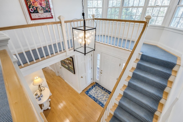 foyer entrance with stairs, light wood-type flooring, and a notable chandelier