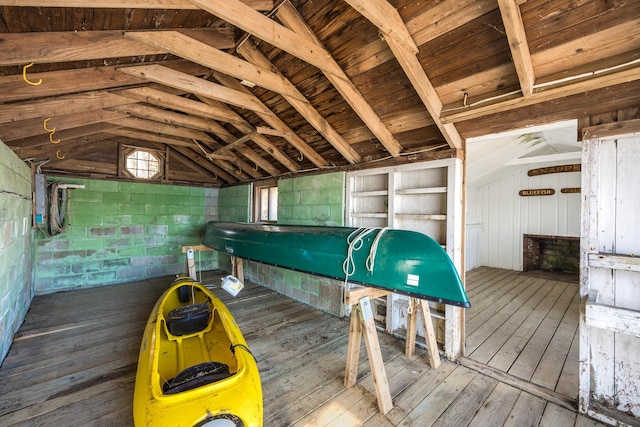 interior space featuring concrete block wall, hardwood / wood-style flooring, and vaulted ceiling