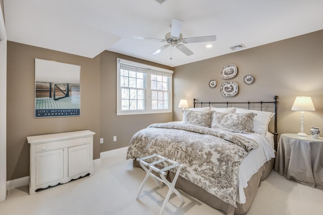 bedroom featuring a ceiling fan, visible vents, light carpet, and baseboards