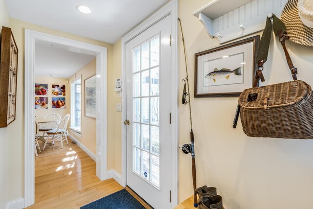 doorway with baseboards and light wood-style floors