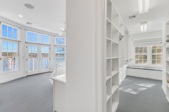 spacious closet with french doors, carpet, visible vents, and a ceiling fan