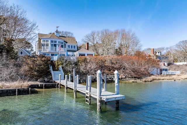 view of dock featuring a water view, a balcony, and stairway