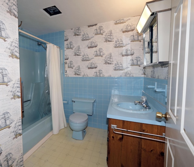 full bathroom featuring vanity, toilet, a wainscoted wall, tile walls, and shower / tub combo