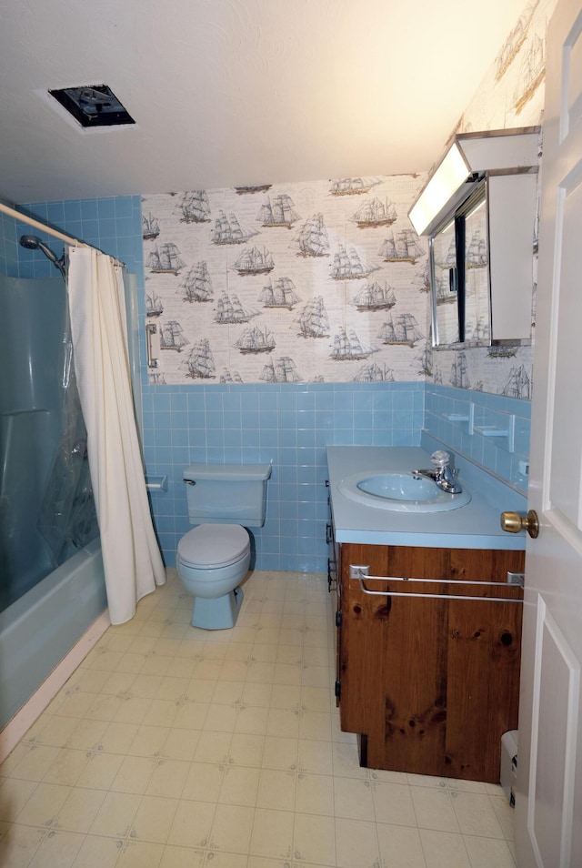 full bathroom featuring tile walls, vanity, tile patterned floors, toilet, and shower / bath combo with shower curtain