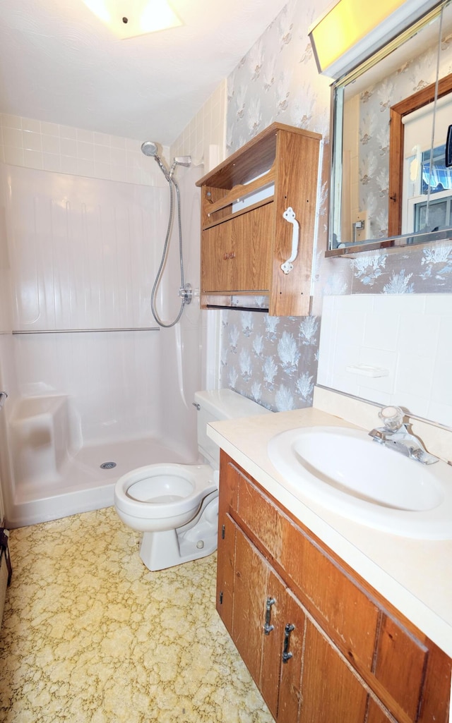 full bath featuring vanity, a shower, toilet, and wallpapered walls