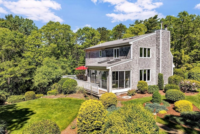 17 Claus Way, Marstons Mills, MA 02648 - rear view of house featuring a chimney, a wooden deck, and a yard
