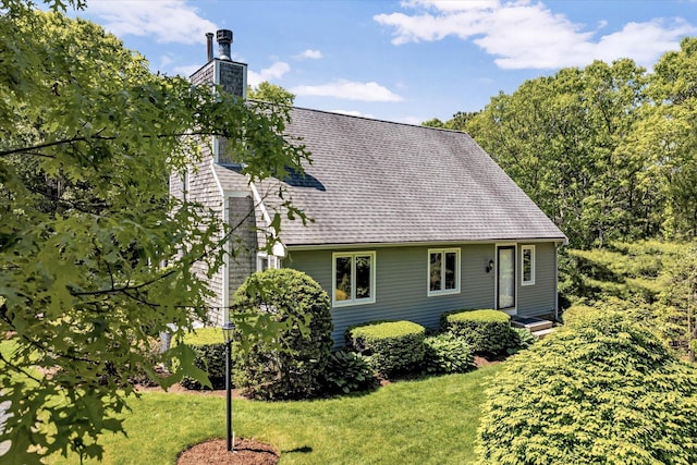 17 Claus Way, Marstons Mills, MA 02648 - back of property with a chimney, a shingled roof, and a lawn
