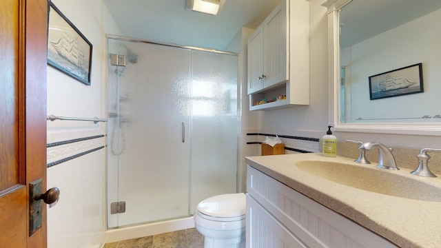 bathroom with vanity, a shower with shower door, and toilet