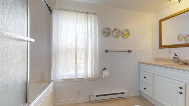 bathroom with combined bath / shower with glass door, tile patterned floors, a baseboard heating unit, and vanity