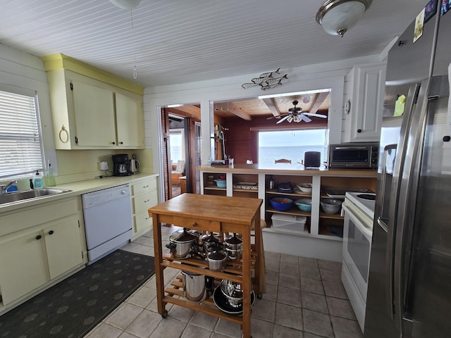 kitchen featuring ceiling fan, sink, white appliances, and light tile patterned floors