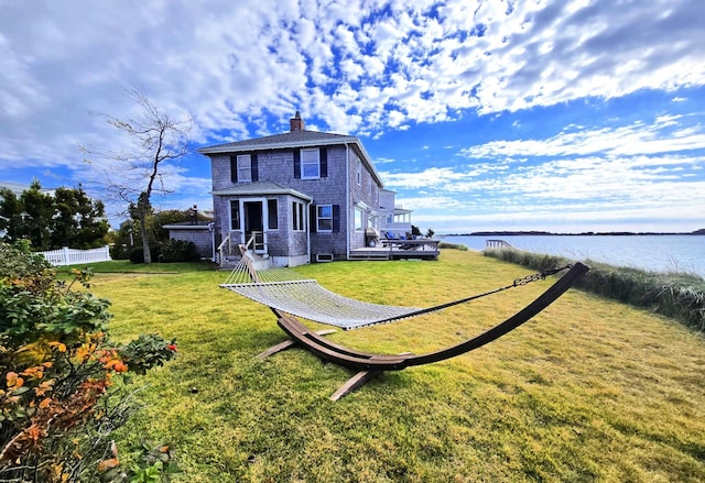 exterior space with a deck with water view and a yard