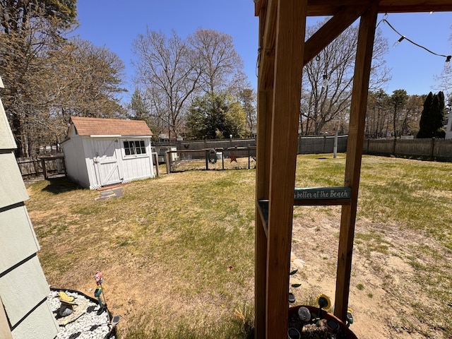 view of yard with an outdoor structure, a fenced backyard, and a shed