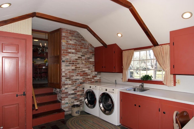 washroom with sink, brick wall, washing machine and dryer, and cabinets