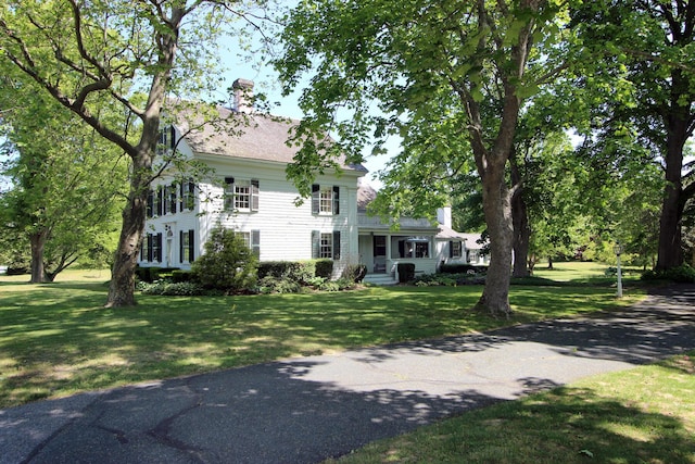 colonial-style house featuring a front yard