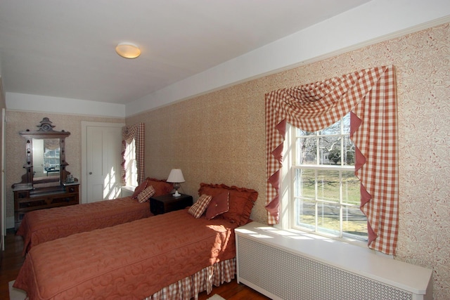 bedroom with radiator heating unit and hardwood / wood-style floors