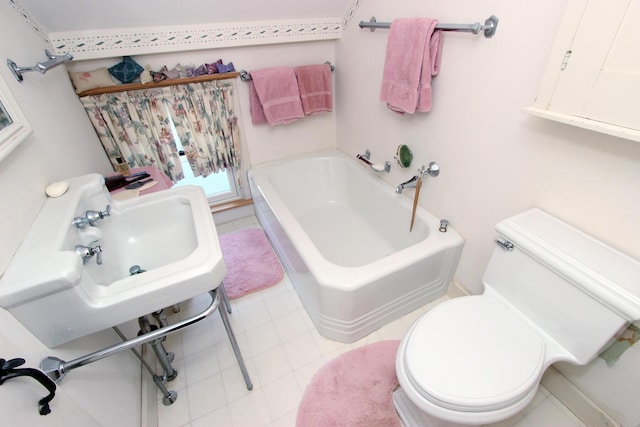 bathroom with a washtub, toilet, and sink