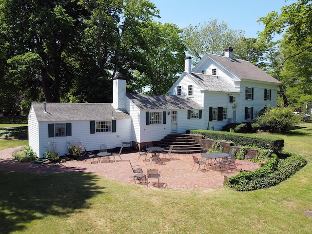 back of property with a patio area and a yard