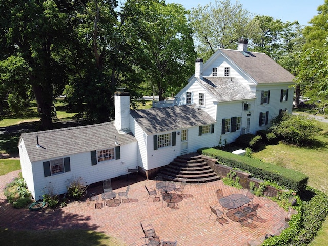 rear view of property featuring a lawn and a patio