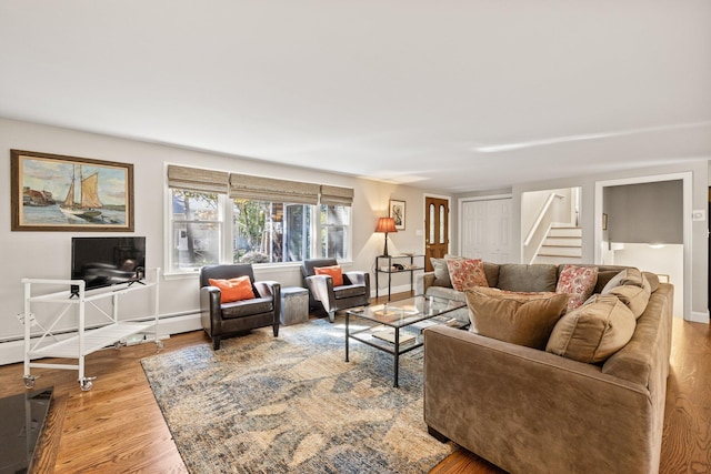 living room with wood-type flooring and a baseboard heating unit