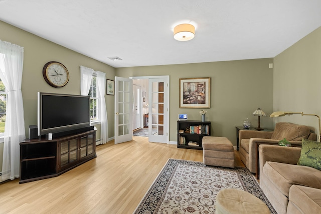 4 Canterbury Ln, Bourne, MA 02532 - living area with french doors, wood finished floors, baseboards, and baseboard heating