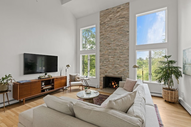 4 Canterbury Ln, Bourne, MA 02532 - living room with high vaulted ceiling, a baseboard heating unit, wood finished floors, and a stone fireplace