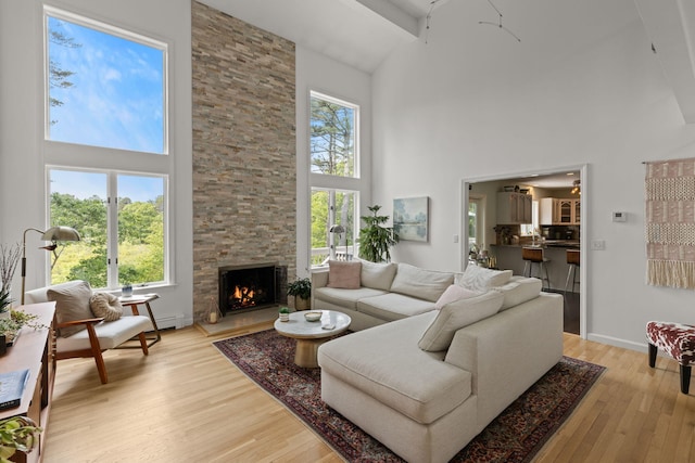 4 Canterbury Ln, Bourne, MA 02532 - living area featuring high vaulted ceiling, light wood-type flooring, a fireplace, and baseboards
