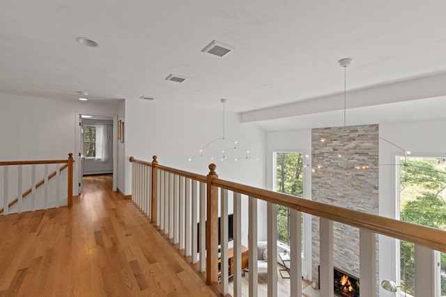 4 Canterbury Ln, Bourne, MA 02532 - corridor with an upstairs landing, light wood-style flooring, healthy amount of natural light, and a chandelier