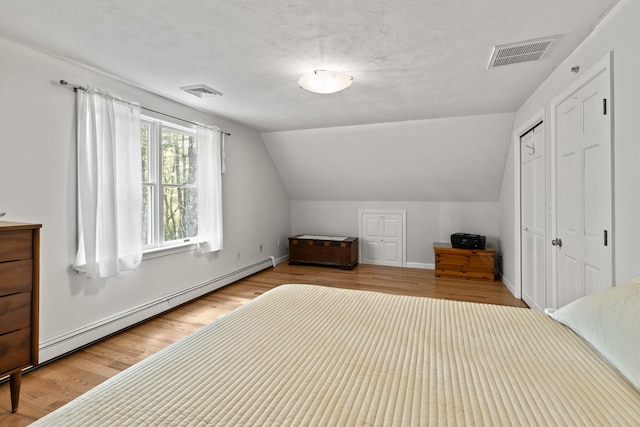 4 Canterbury Ln, Bourne, MA 02532 - bedroom featuring a baseboard heating unit, wood finished floors, lofted ceiling, baseboards, and a closet