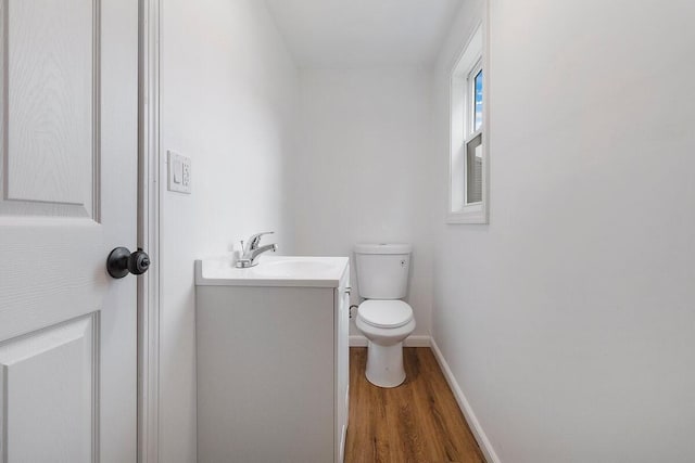 bathroom with wood-type flooring, toilet, and vanity