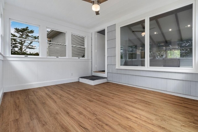 unfurnished sunroom featuring a healthy amount of sunlight and ceiling fan