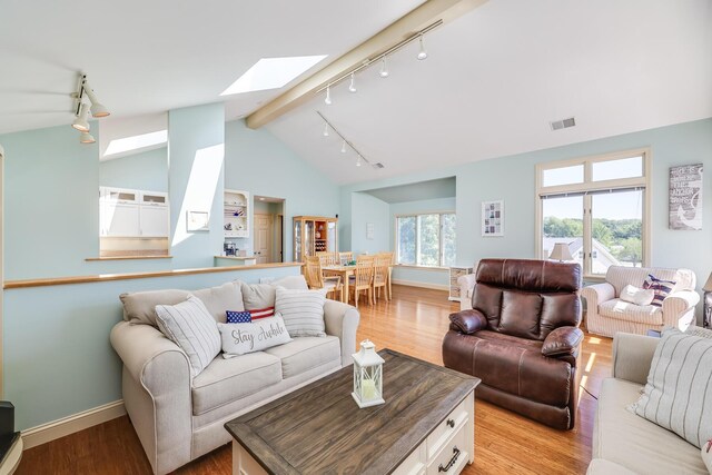 living room with light wood-type flooring and lofted ceiling with skylight