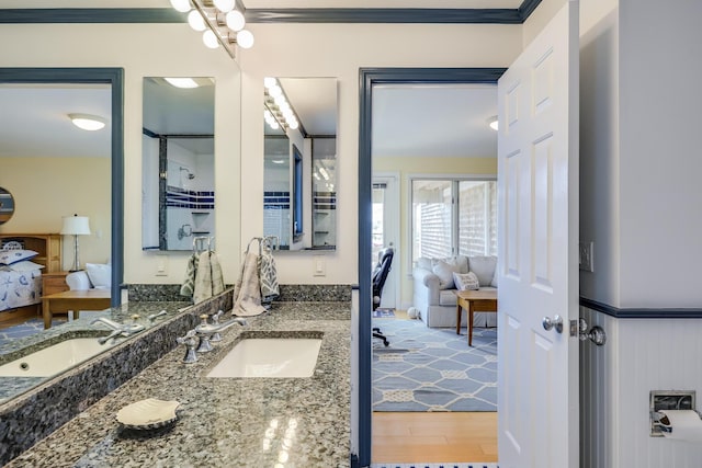 bathroom featuring vanity, hardwood / wood-style flooring, and crown molding