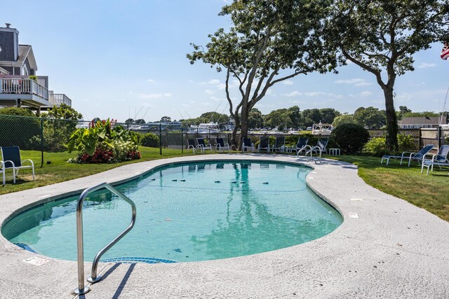 view of pool with a lawn