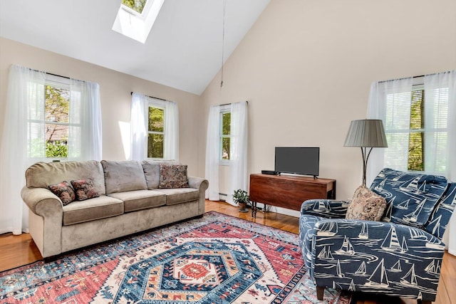 17 Greenway Cir, Sandwich, MA 02563 - living area with wood finished floors, healthy amount of natural light, high vaulted ceiling, a skylight, and a baseboard heating unit