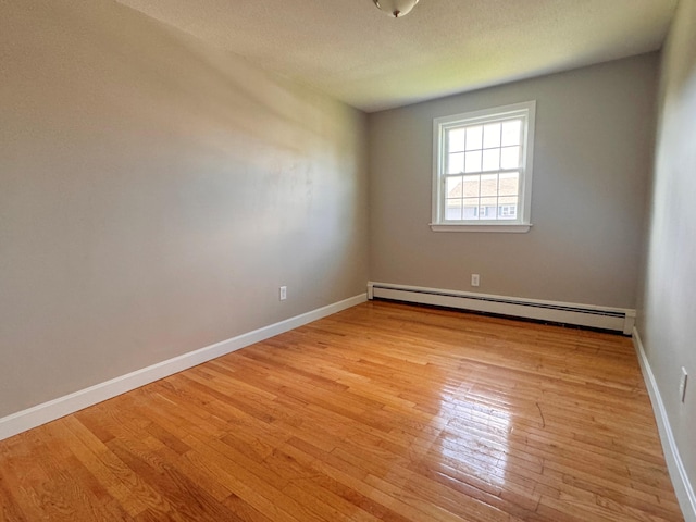 spare room featuring light hardwood / wood-style flooring and baseboard heating