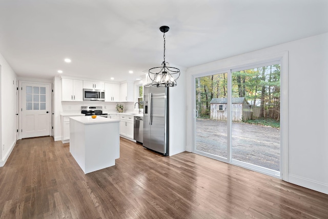 kitchen with white cabinets, hanging light fixtures, appliances with stainless steel finishes, and sink