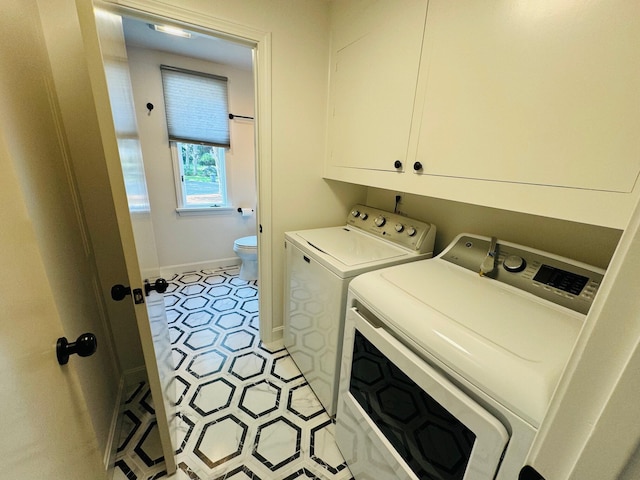 131 Portside Cir E, Falmouth, MA 02536 - laundry area with washing machine and clothes dryer, light tile patterned floors, and cabinet space