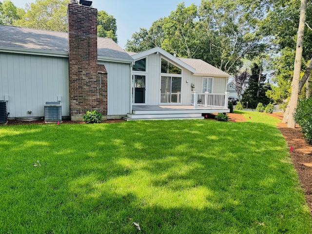 131 Portside Cir E, Falmouth, MA 02536 - rear view of house with a wooden deck, a chimney, a lawn, and roof with shingles