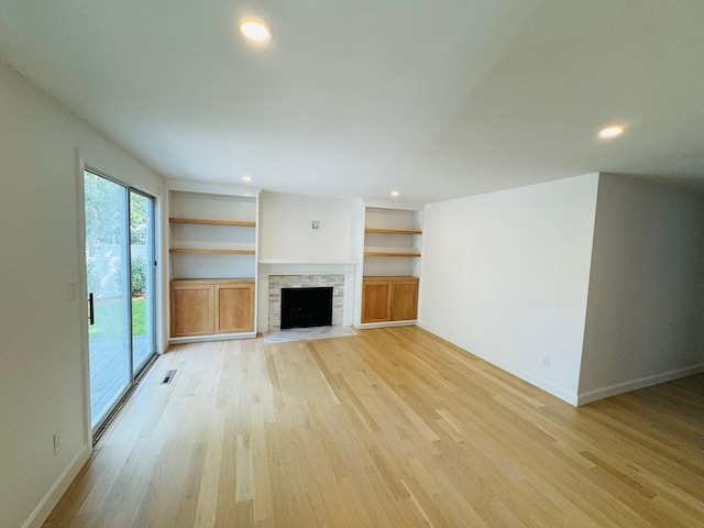 131 Portside Cir E, Falmouth, MA 02536 - unfurnished living room featuring light wood-style floors, a fireplace with flush hearth, recessed lighting, and built in shelves