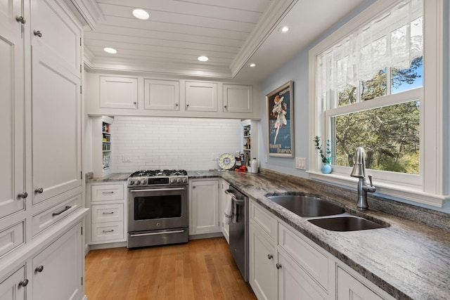 116 Happy Valley Rd, Chatham, MA 02633 - kitchen featuring stainless steel appliances, white cabinets, tasteful backsplash, a sink, and light wood finished floors