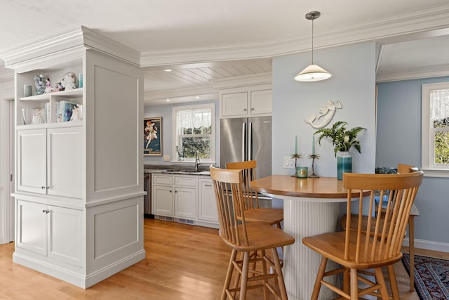 116 Happy Valley Rd, Chatham, MA 02633 - kitchen featuring light wood-style floors, healthy amount of natural light, ornamental molding, pendant lighting, and a sink
