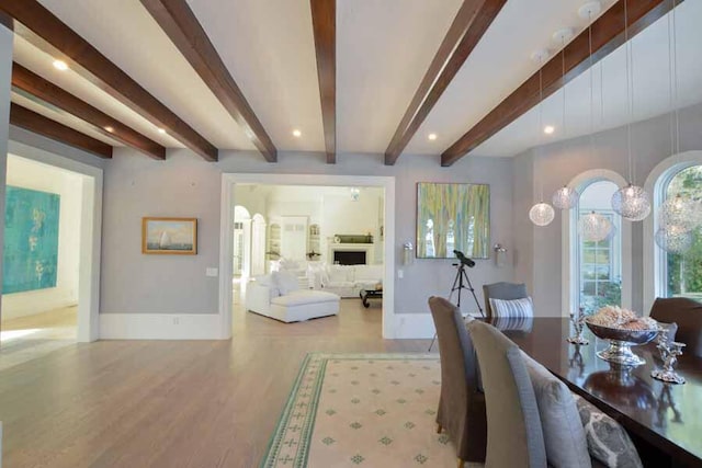 dining area with beamed ceiling and light hardwood / wood-style flooring