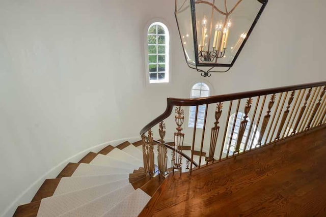 staircase with an inviting chandelier